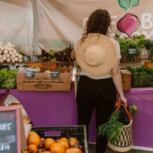 Woman shopping at a farmer's market with Oval Basket