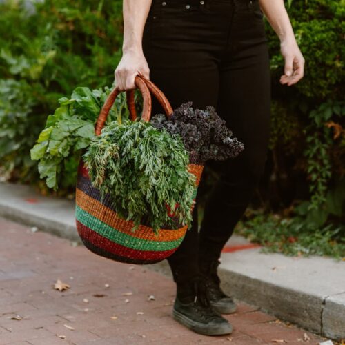 Person carrying a Shopping Tote Bolga Basket full of produce