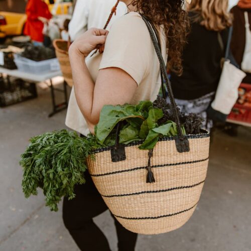 Woman in a Market with fresh produce in Shoulder Bag