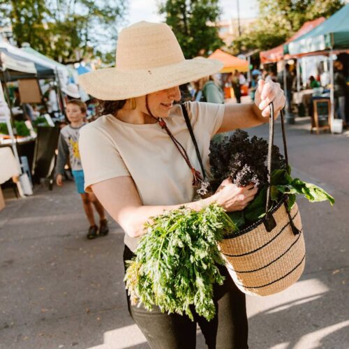 Woman shopping in a farmers market with African Shoulder Bag