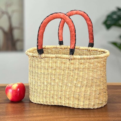 Small oval woven basket next to an apple