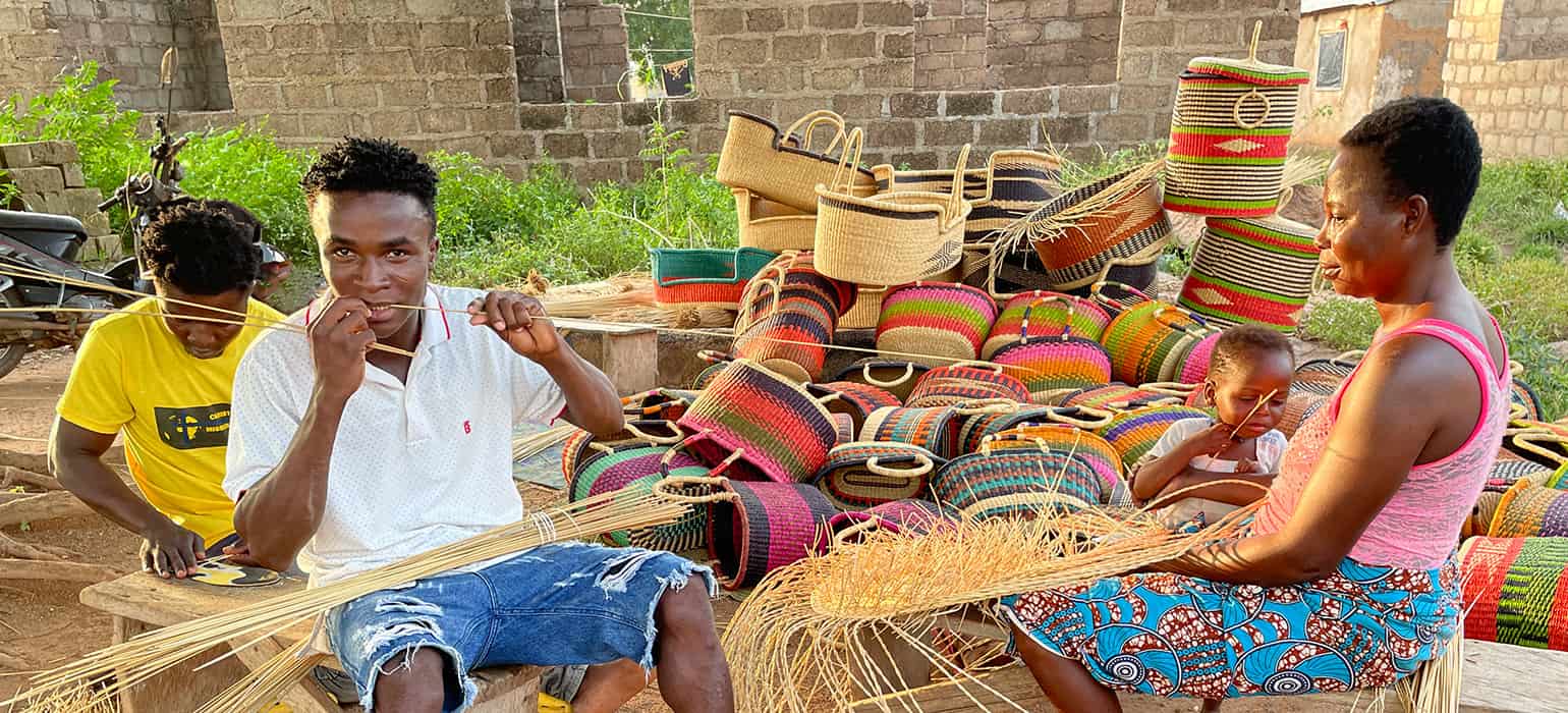 Two Men and a Woman weaving baskets in Africa
